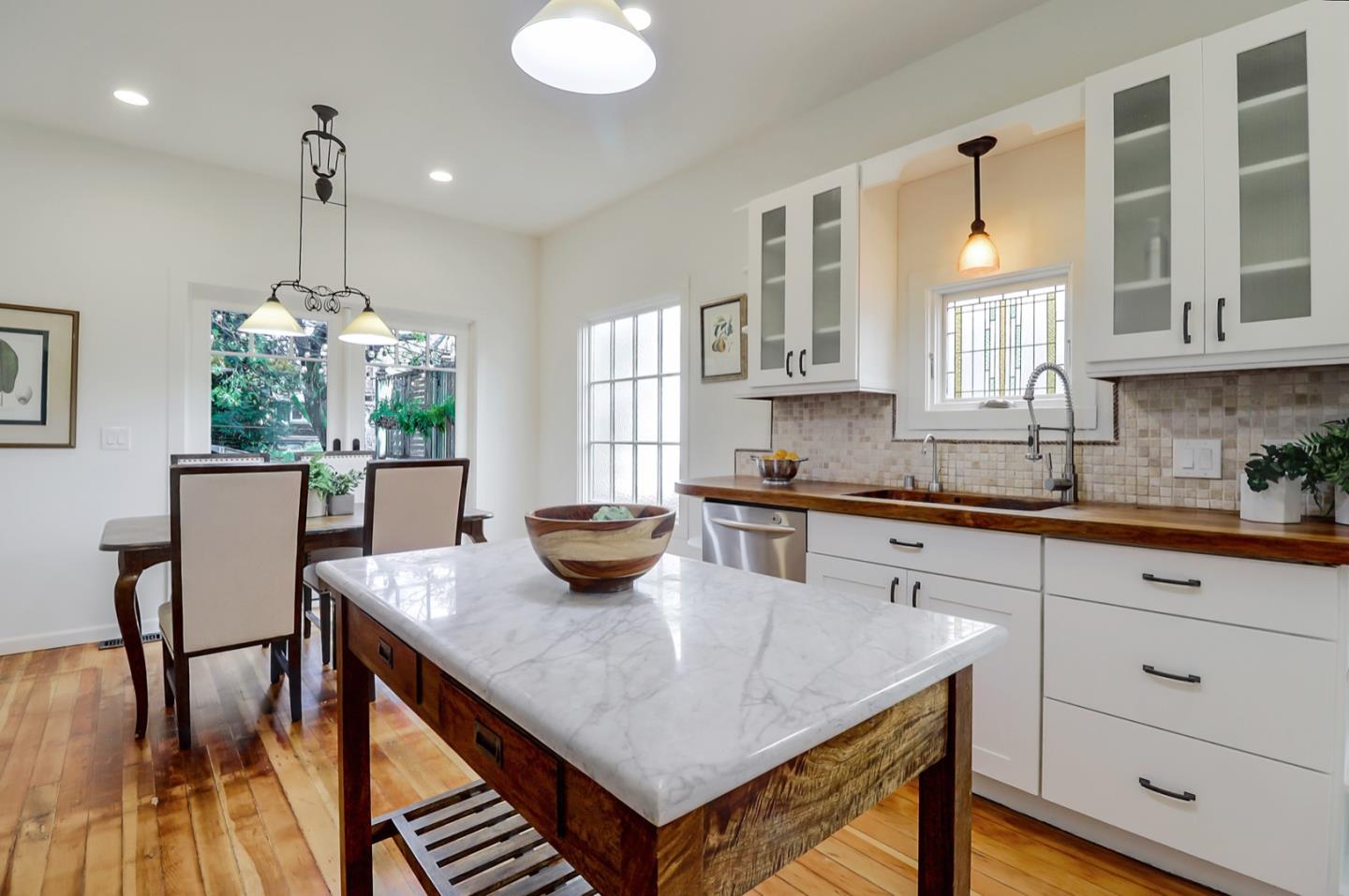 2614 Etna Street Berkeley, CA 94704 - Photo 18 of 59 a kitchen with a table chairs and white cabinets