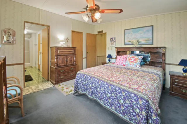 a bedroom with a bed a chandelier and dresser