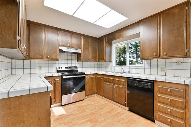 a kitchen with a stove sink and cabinets