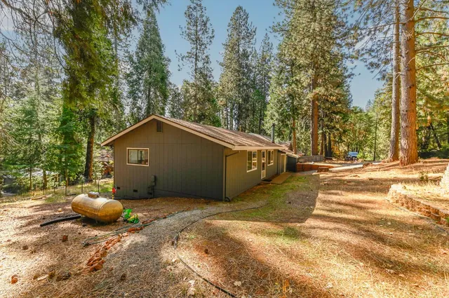 a backyard of a house with table and chairs in a patio