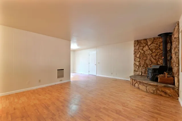 a view of an empty room with wooden floor and shoes