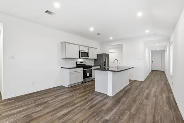 a kitchen with a refrigerator and white cabinets