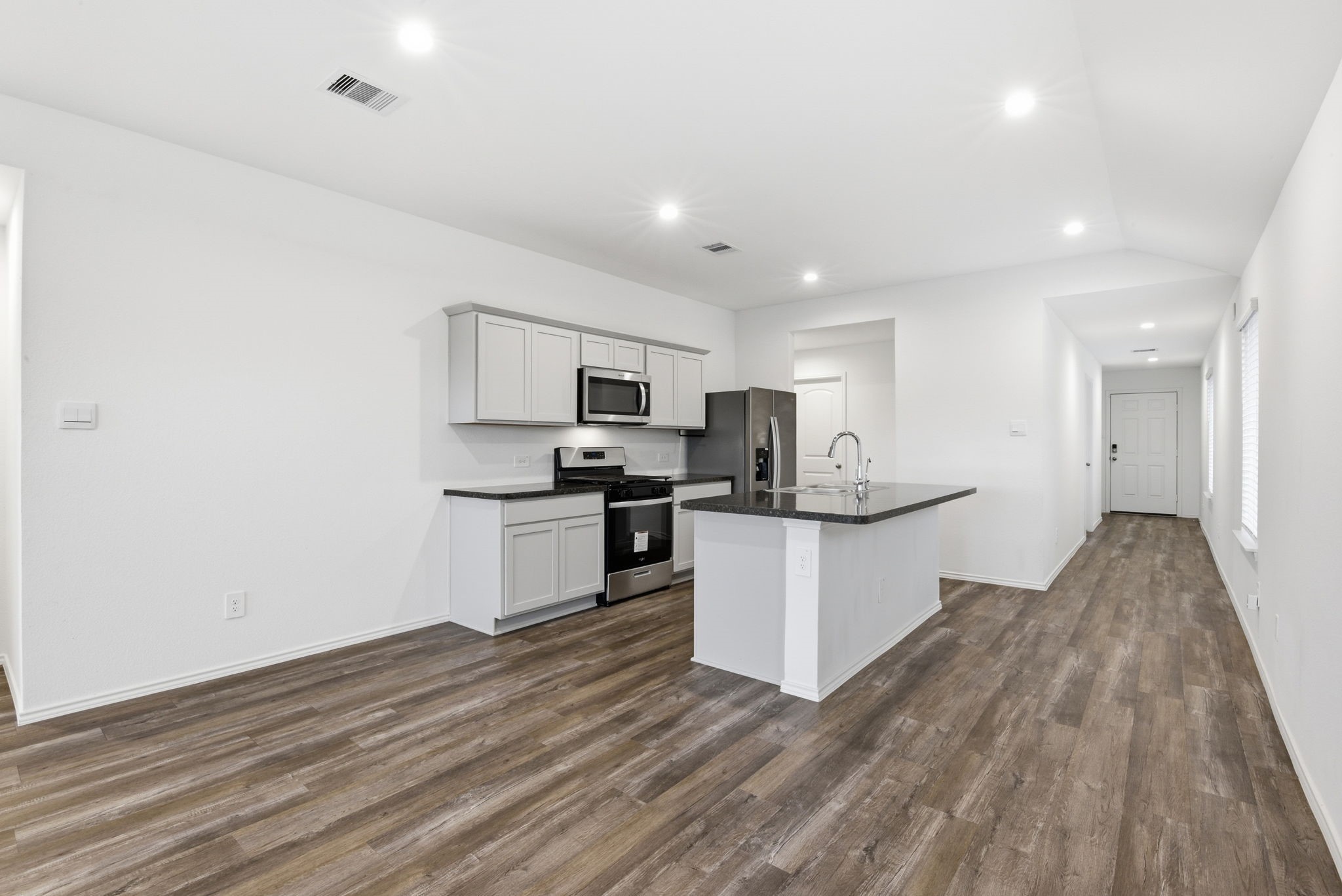 24343 Saddlestone Green Drive Spring, TX 77373 - Photo 14 of 43 a kitchen with a refrigerator and white cabinets