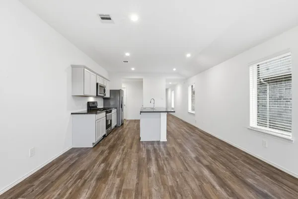 a kitchen with a refrigerator and white cabinets