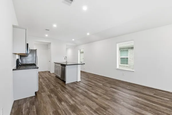 a view of kitchen with stainless steel appliances granite countertop a stove and a refrigerator