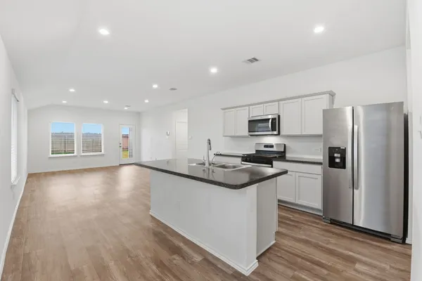a kitchen with stainless steel appliances granite countertop a sink stove and refrigerator