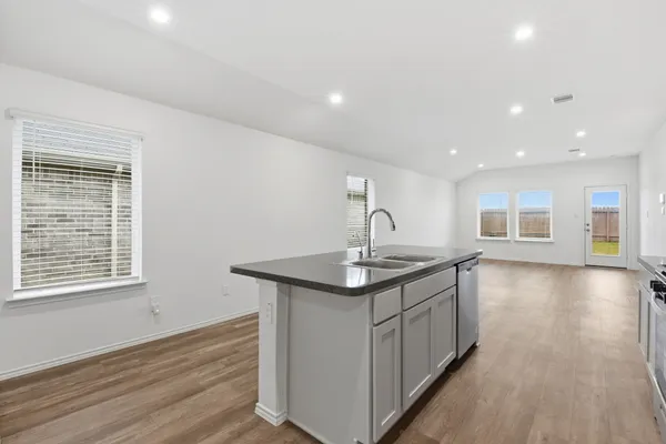 a kitchen with a sink and wooden floor