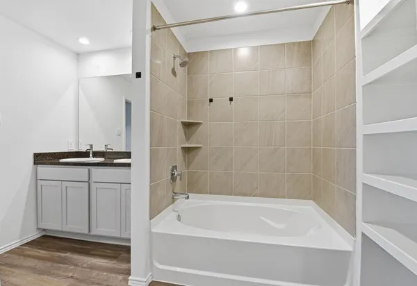 a bathroom with a tub a sink and a shower