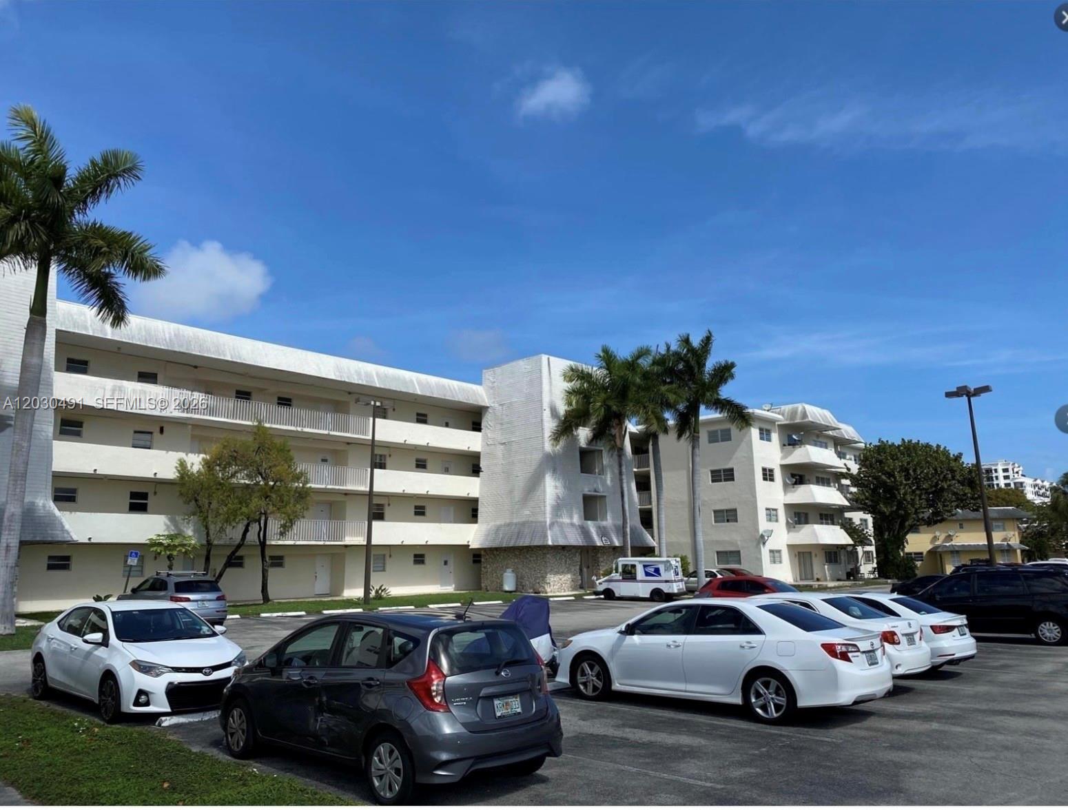 7410 Southwest 82nd Street, Unit K401 Miami, FL 33143 - Photo 4 of 5 a front view of a building with cars parked