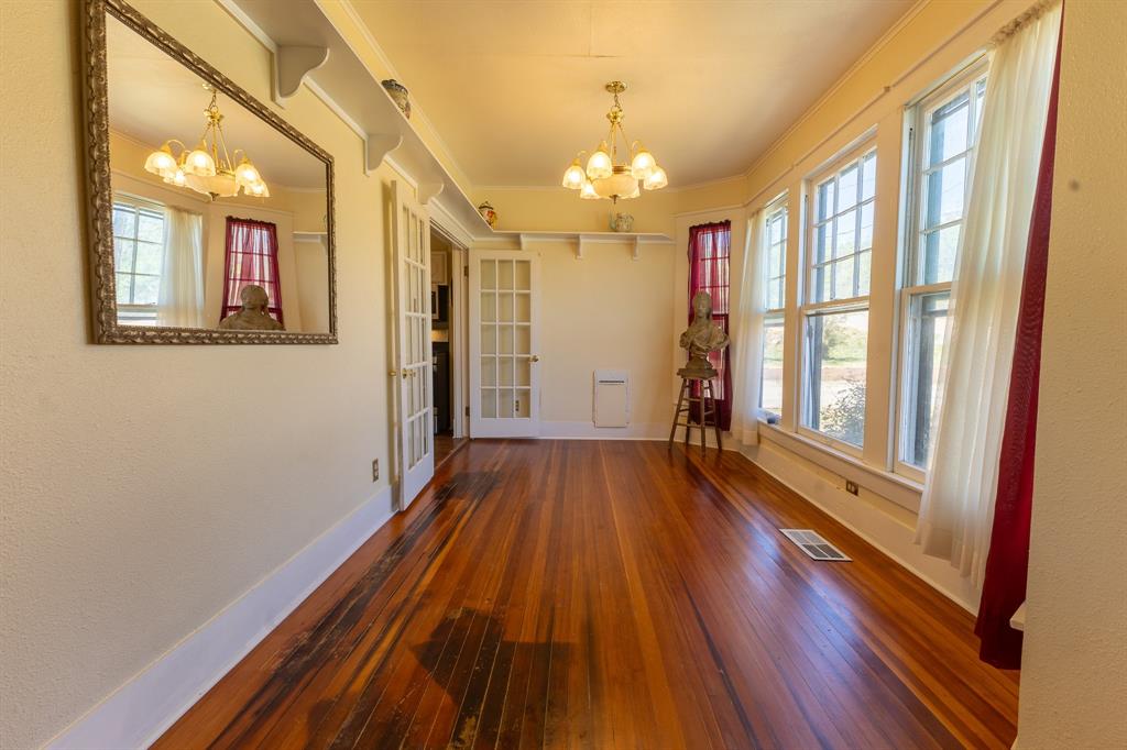 1115 Austin Street Coleman, TX 76834 - Photo 13 of 40 wooden floor in an empty room with a window