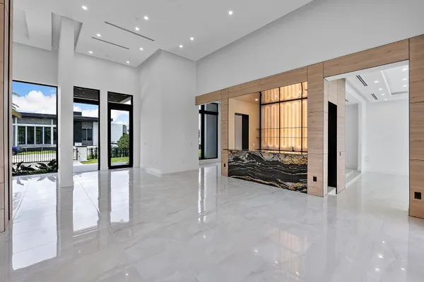 a view of an empty room with wooden floor and floor to ceiling window