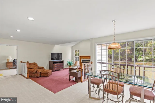 a open kitchen with stainless steel appliances granite countertop a stove top oven a dining table and chairs