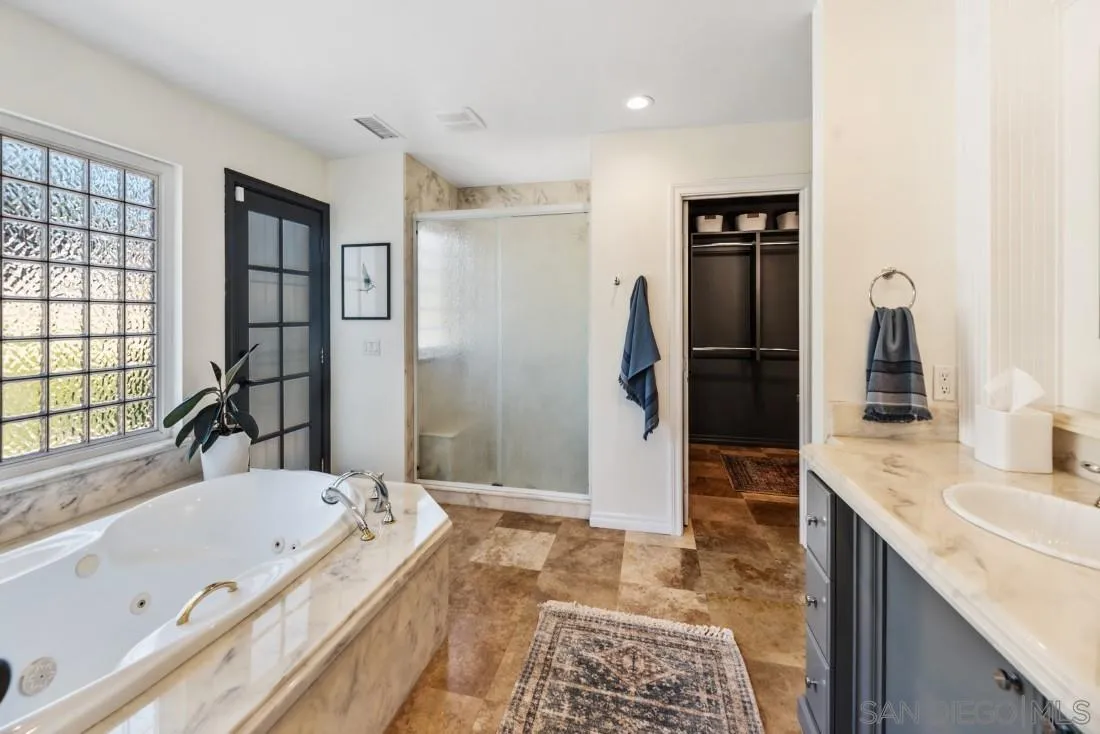 13060 Camino Del Valle Poway, CA 92064 - Photo 30 of 75 a bathroom with a granite countertop tub sink a shower and a mirror