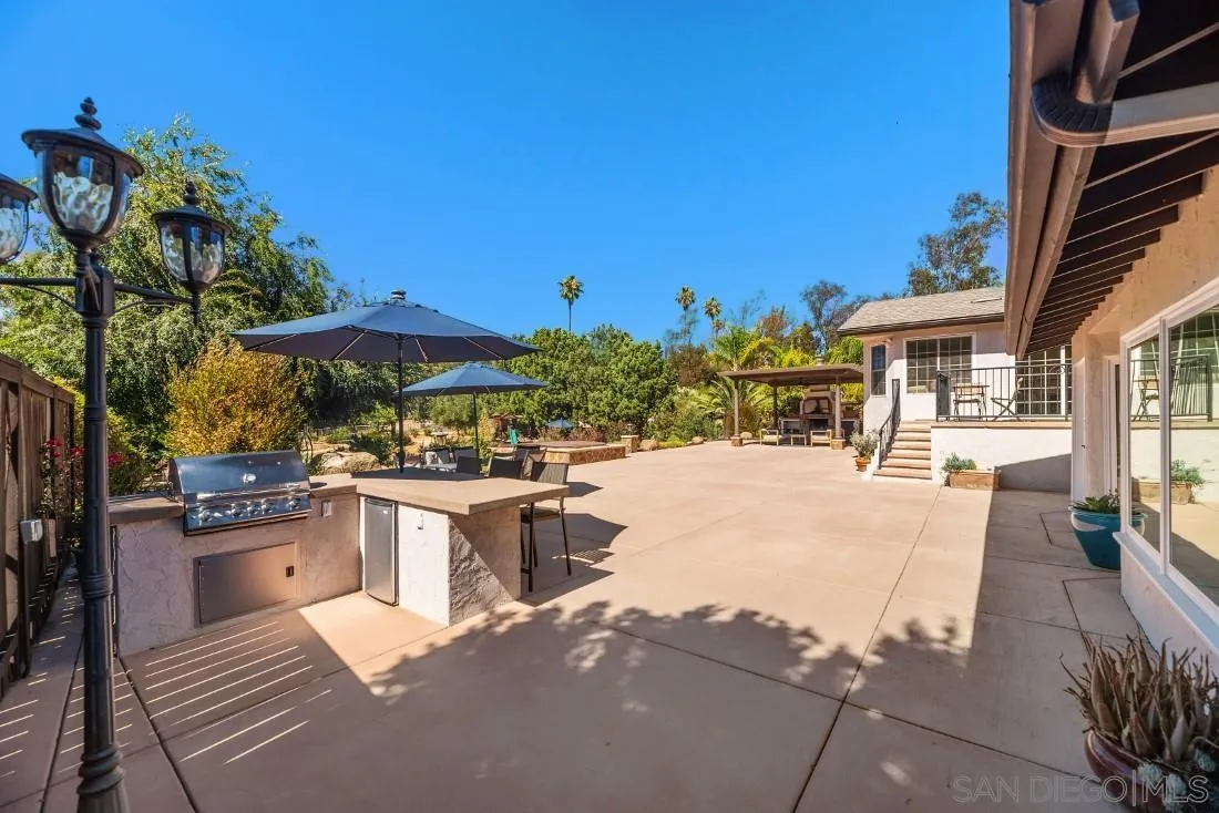 13060 Camino Del Valle Poway, CA 92064 - Photo 46 of 75 a view of a patio with chairs and tables under an umbrella