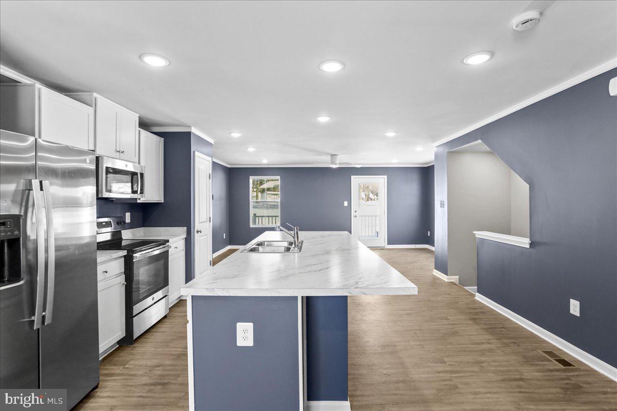 46 Scoter Road Hedgesville, WV 25427 - Photo 8 of 28 a large kitchen with stainless steel appliances granite countertop a sink dishwasher a refrigerator and a stove with wooden floor