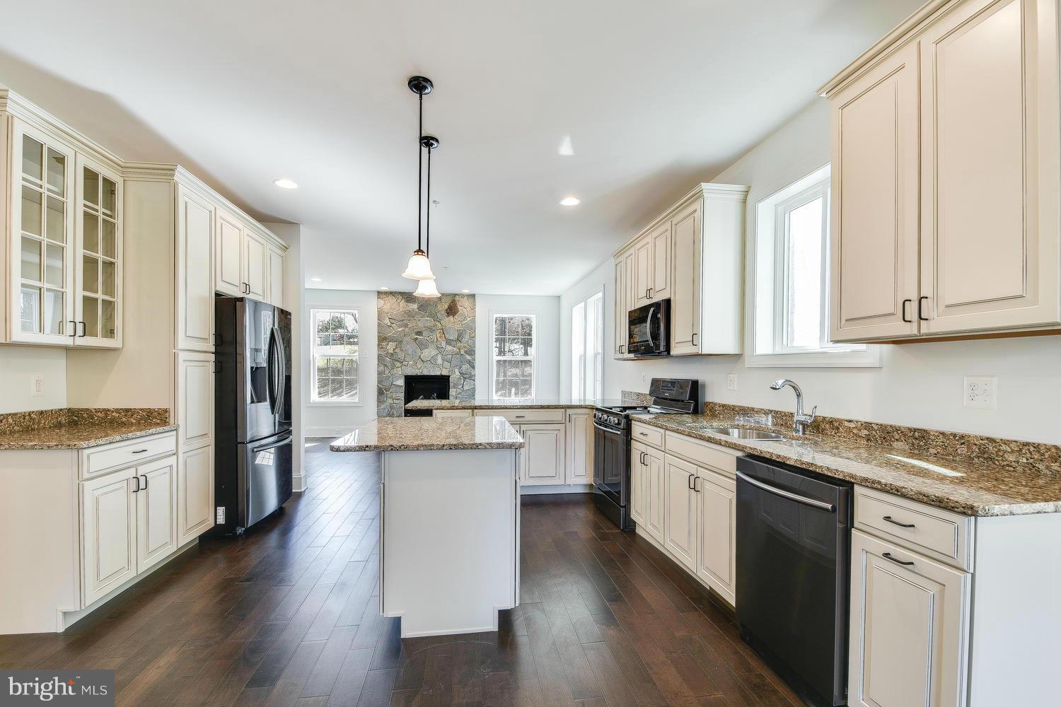 3526 Kemptown Church Road Monrovia, MD 21770 - Photo 12 of 29 a kitchen with stainless steel appliances granite countertop a refrigerator a stove top oven a sink dishwasher and a refrigerator with wooden floor