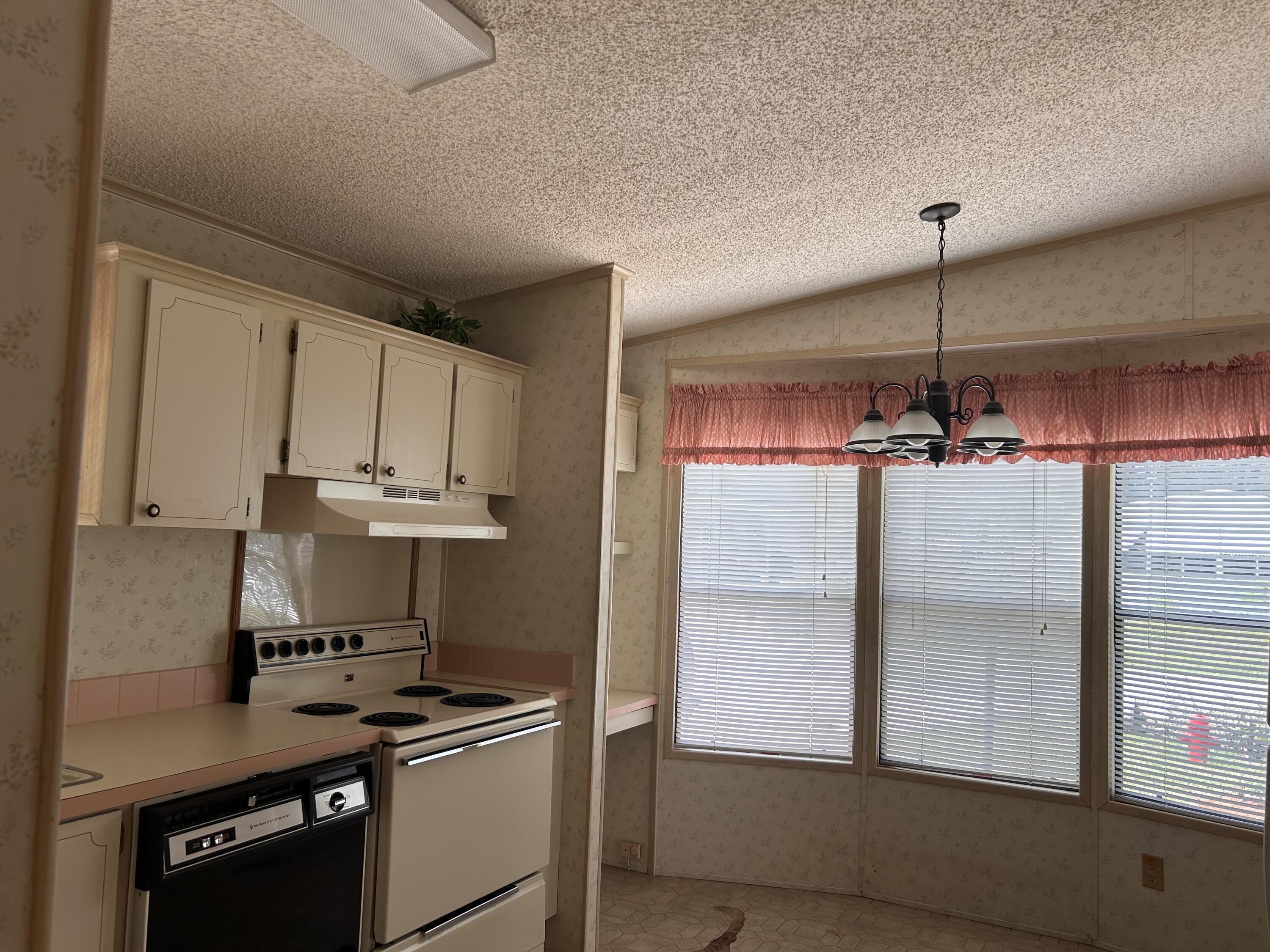 2828 Southwest Toronado Trail Stuart, FL 34997 - Photo 11 of 23 a kitchen with a refrigerator a stove and a window