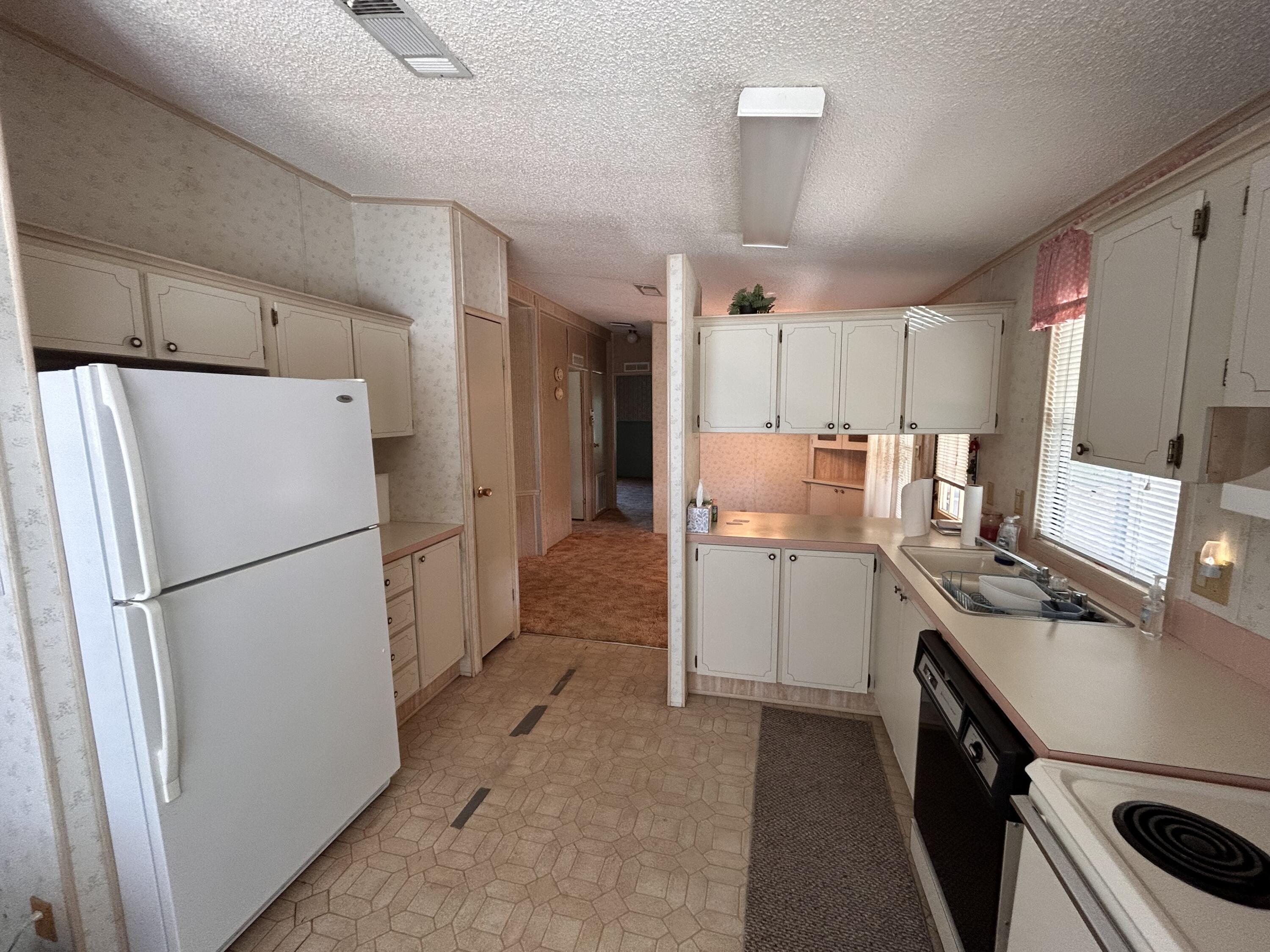 2828 Southwest Toronado Trail Stuart, FL 34997 - Photo 12 of 23 a kitchen with a refrigerator a stove top oven and a sink