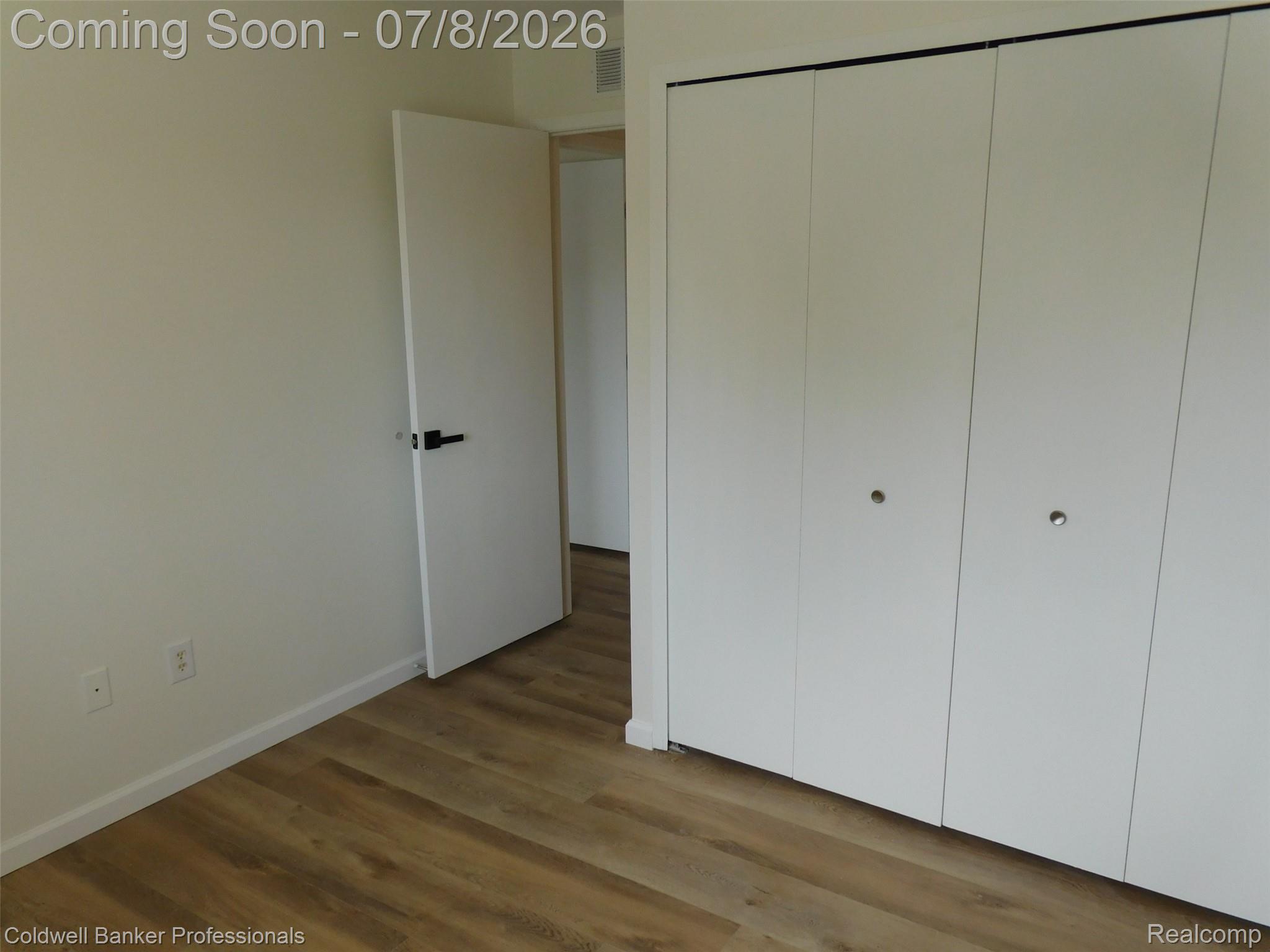 284 East 13 Mile Road Madison Heights, MI 48071 - Photo 19 of 21 Interior space featuring wood-finish flooring, white walls, and a white interior door with black hardware