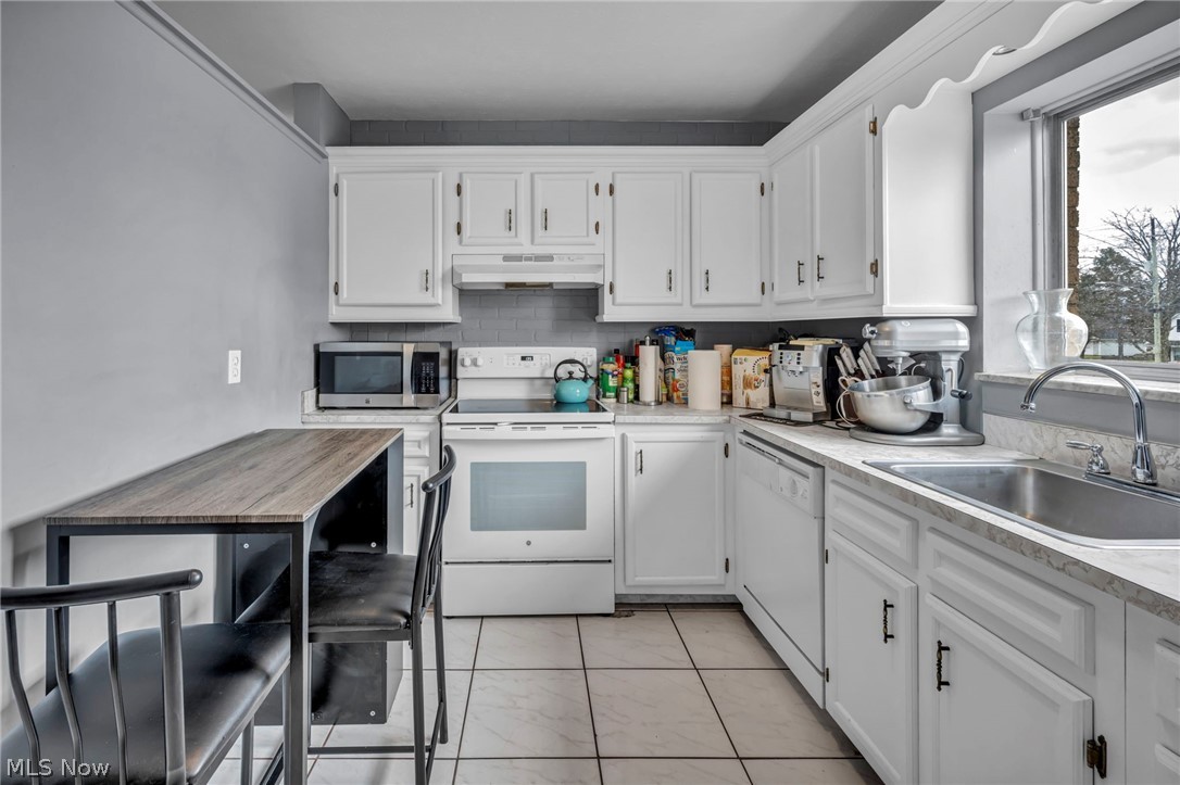 5200 Royalton Road, Unit 9B North Royalton, OH 44133 - Photo 12 of 27 Kitchen featuring white appliances, light countertops, white cabinetry, and backsplash