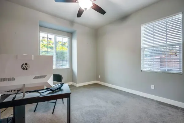 a spacious bedroom with a bed and a ceiling fan