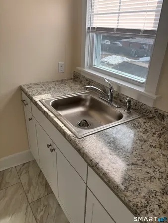 a large white kitchen with granite countertop a sink