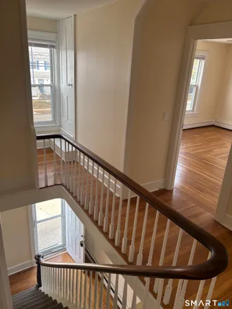 a view of a hallway with wooden floor and a window