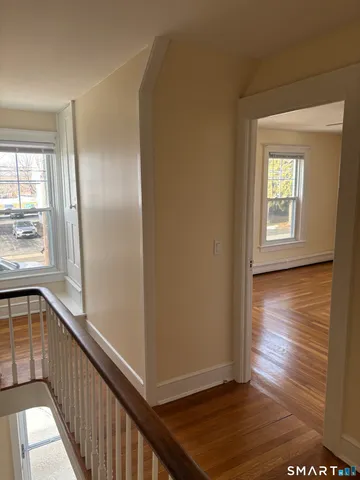 a view of empty room with wooden floor