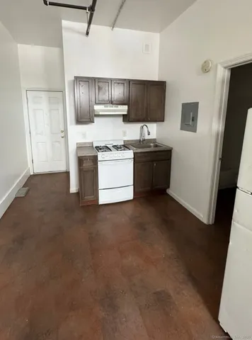 a kitchen with stainless steel appliances a refrigerator a sink a stove a microwave a counter top and cabinets