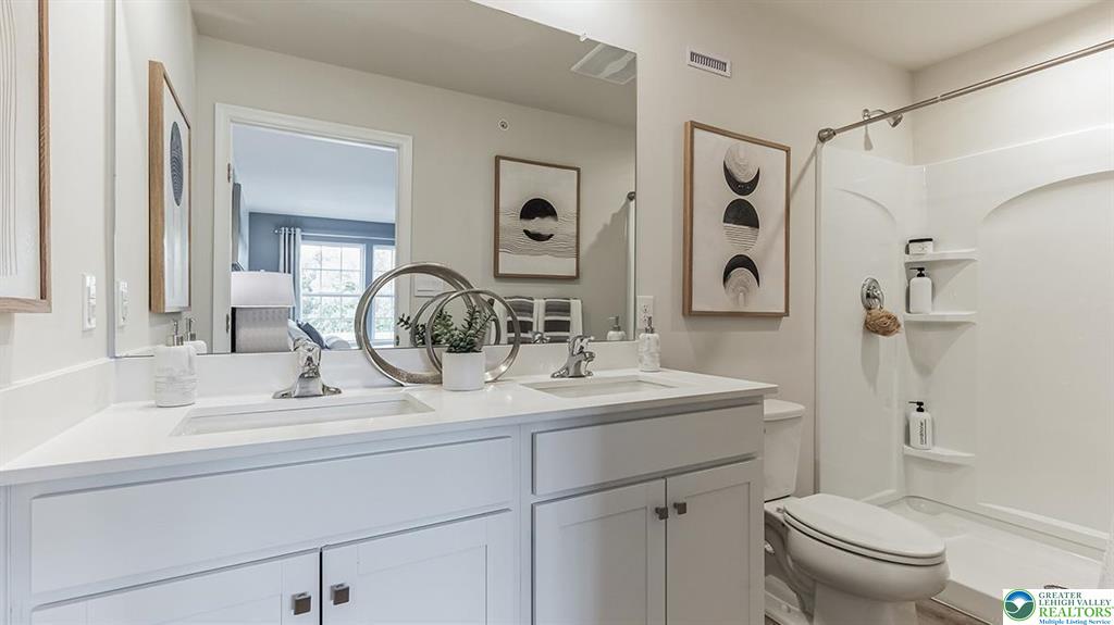 1145 Martin Road Breinigsville, PA 18031 - Photo 16 of 38 Dual vanities with pristine white countertops provide ample space in this bright and modern bathroom.