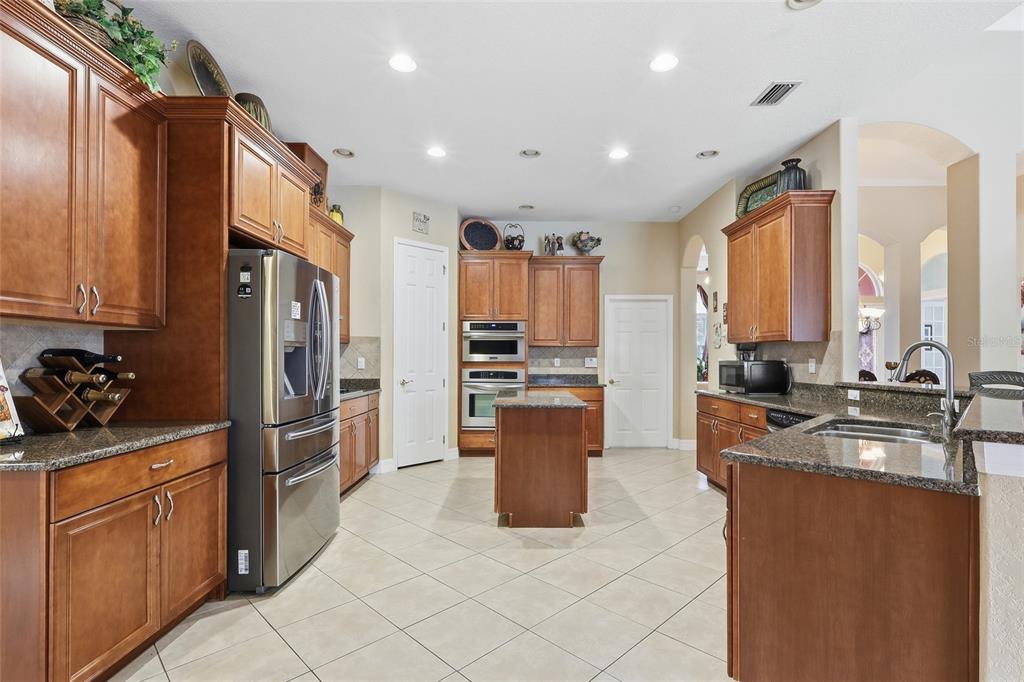 11749 Newberry Grove Loop Riverview, FL 33579 - Photo 11 of 54 a kitchen with stainless steel appliances granite countertop a refrigerator stove and sink
