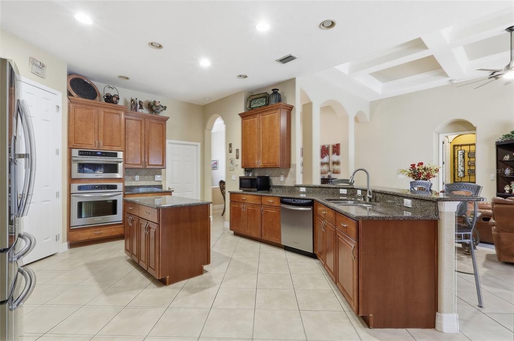 11749 Newberry Grove Loop Riverview, FL 33579 - Photo 13 of 54 a large kitchen with kitchen island a sink a stove a refrigerator and a living room view