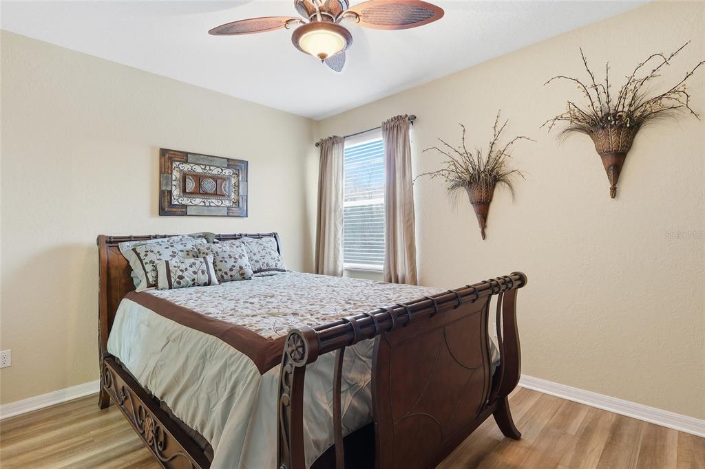 11749 Newberry Grove Loop Riverview, FL 33579 - Photo 34 of 54 a bedroom with a large bed and a chandelier