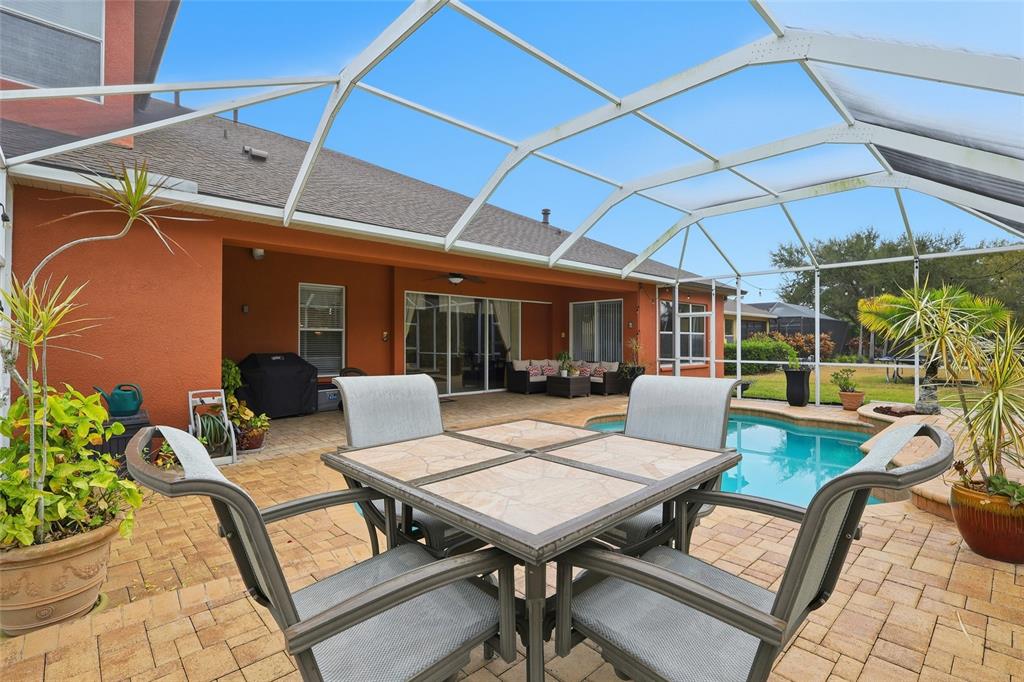 11749 Newberry Grove Loop Riverview, FL 33579 - Photo 38 of 54 a view of a patio with a dining table and chairs with wooden floor
