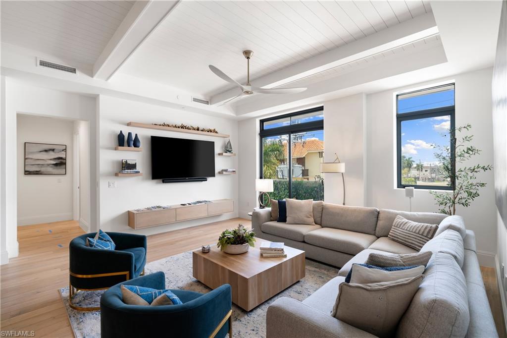 875 6th Avenue South, Unit 304 Naples, FL 34102 - Photo 1 of 40 a living room with furniture a flat screen tv and a large window