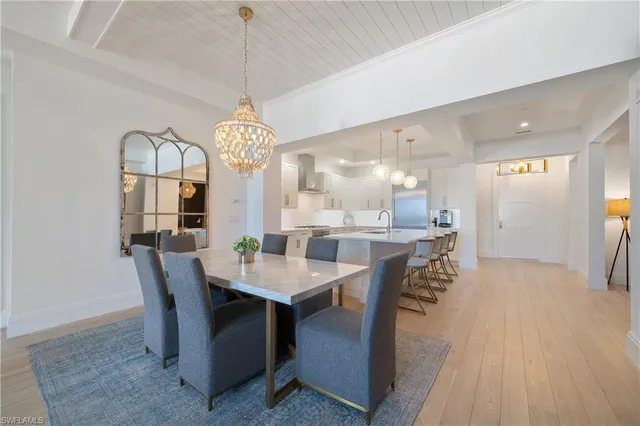 a dining room with furniture a chandelier and wooden floor