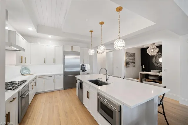 a kitchen that has a lot of cabinets in it and wooden floors