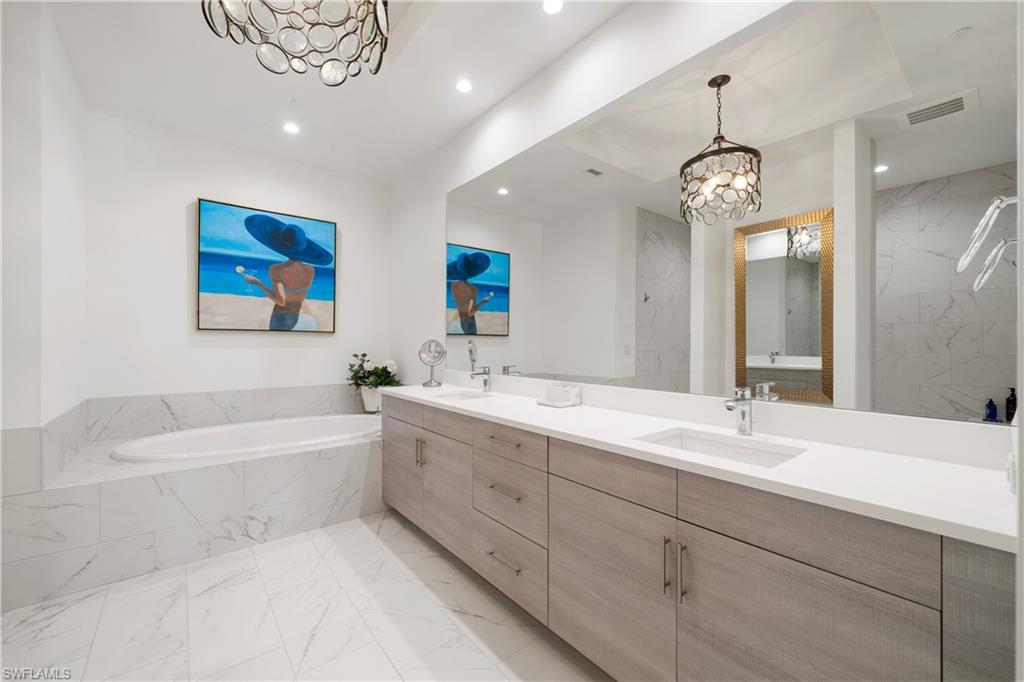 875 6th Avenue South, Unit 304 Naples, FL 34102 - Photo 16 of 40 a spacious bathroom with a large tub sink and mirror