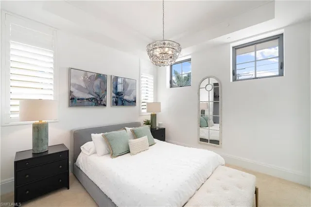 a bedroom with a bed and a chandelier