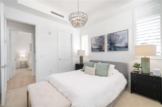 a bedroom with a bed and a chandelier