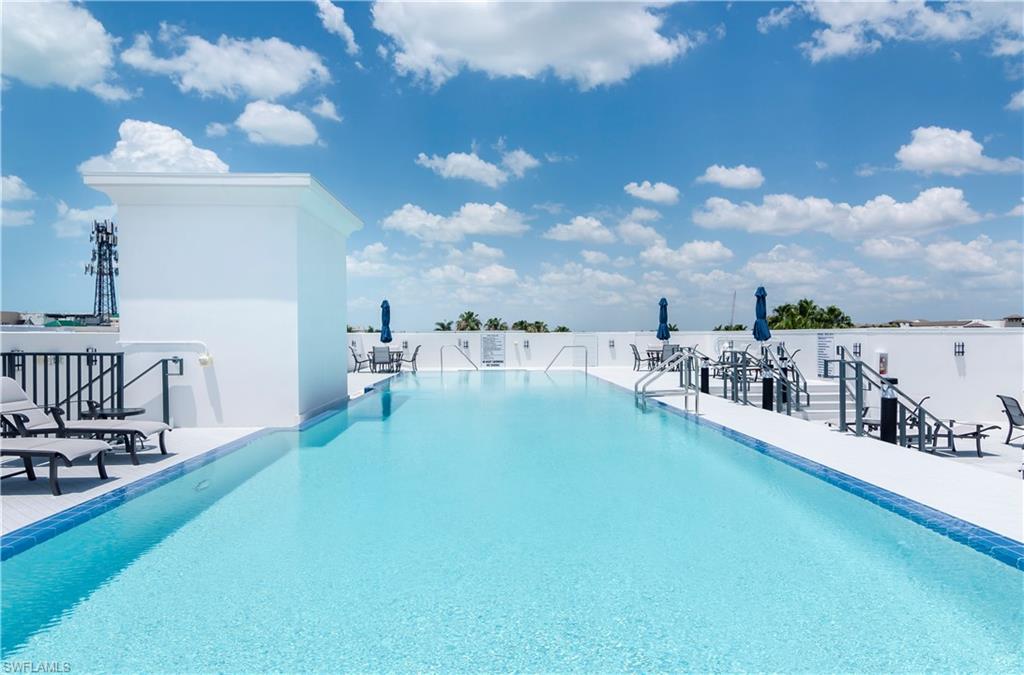 875 6th Avenue South, Unit 304 Naples, FL 34102 - Photo 2 of 40 a view of a swimming pool with table and chairs