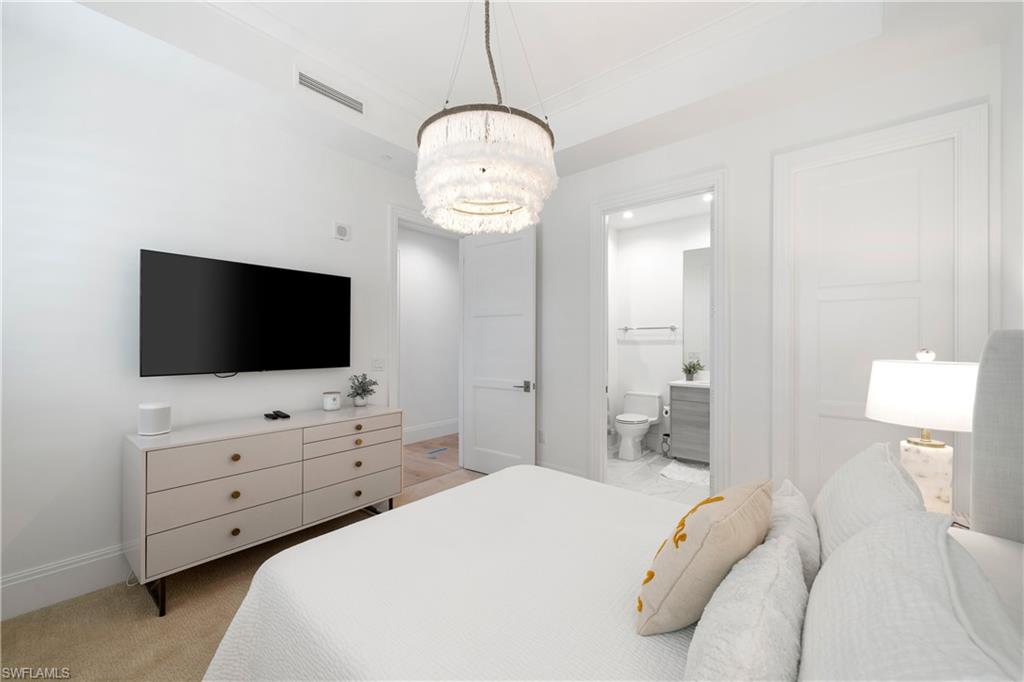 875 6th Avenue South, Unit 304 Naples, FL 34102 - Photo 22 of 40 a bedroom with a bed and flat screen tv