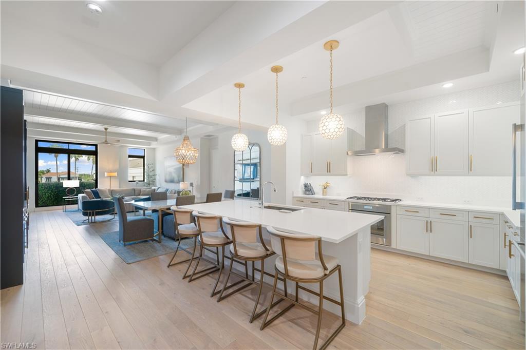 875 6th Avenue South, Unit 304 Naples, FL 34102 - Photo 6 of 40 a large kitchen with a table and chairs