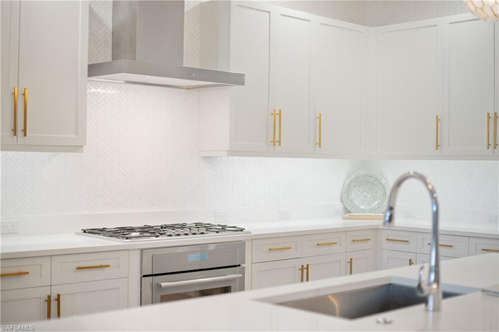 875 6th Avenue South, Unit 304 Naples, FL 34102 - Photo 8 of 40 a kitchen with cabinets a stove and a sink