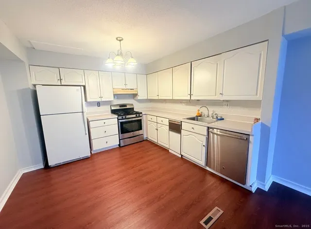 a kitchen with white cabinets and white appliances
