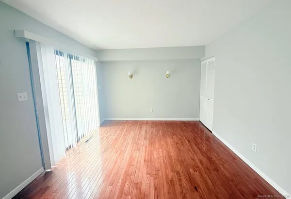 an empty room with wooden floor and a window