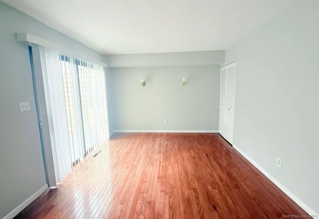 an empty room with wooden floor and a window