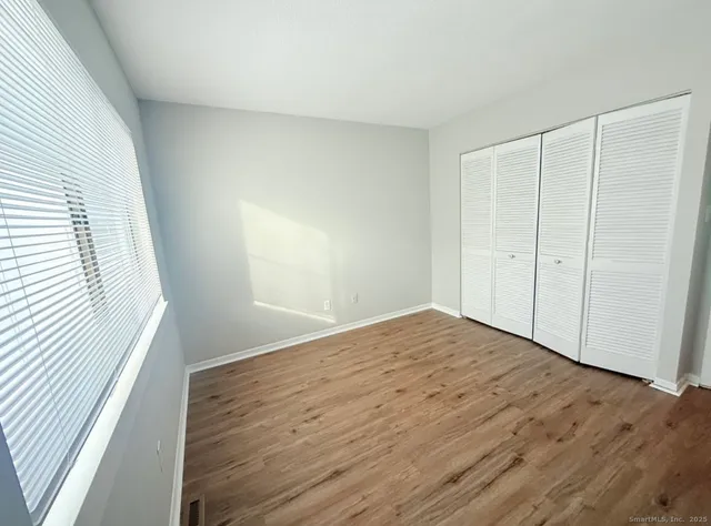 a view of empty room with wooden floor