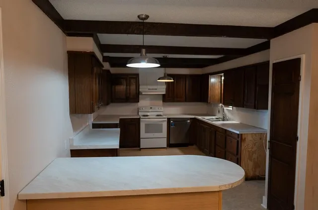 a kitchen with stainless steel appliances a sink and cabinets