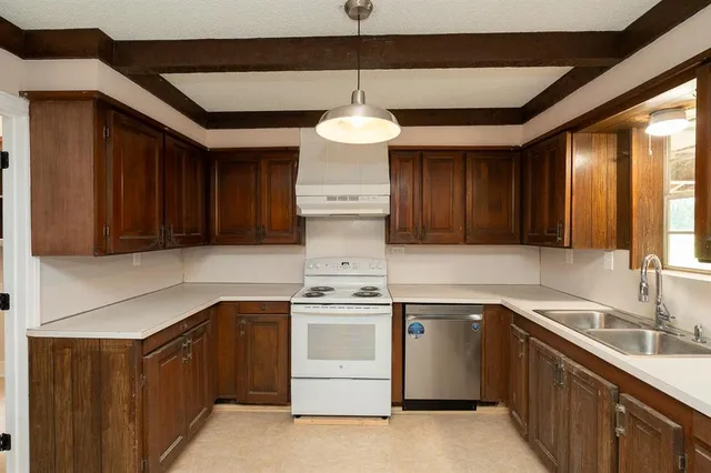 a kitchen with a stove sink and cabinets